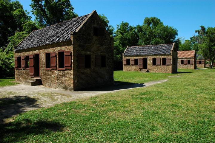 a large brick building with green grass in front of a house